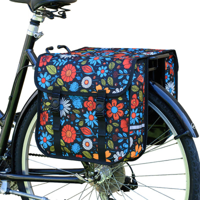 A floral double pannier bag attached to the rear rack of a bicycle.